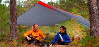 To personer sitter under en tarp